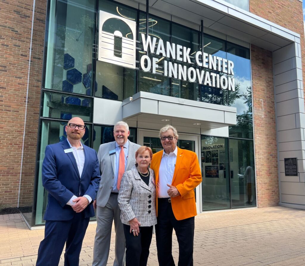 Four people stand in front of a building